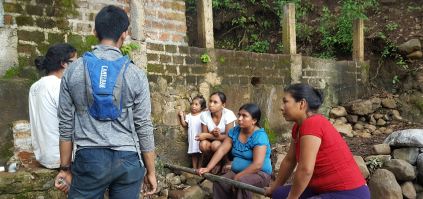 Samir Wadhwania and Geovany Moreno talking with the women of El Sauce about to describe how to connect the pipes that would provide them with water for laundry.