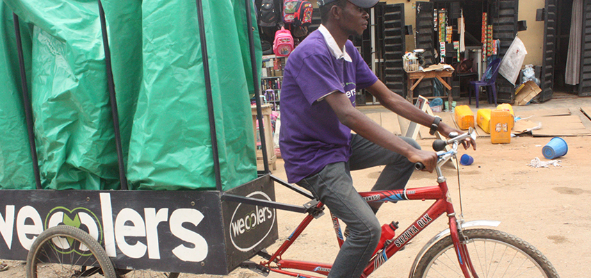 An employee rides one of the Wecyclers' cargo bikes. The startup employs locals to ride door-to-door across the slums of Lagos, Nigeria, to collect recyclables.