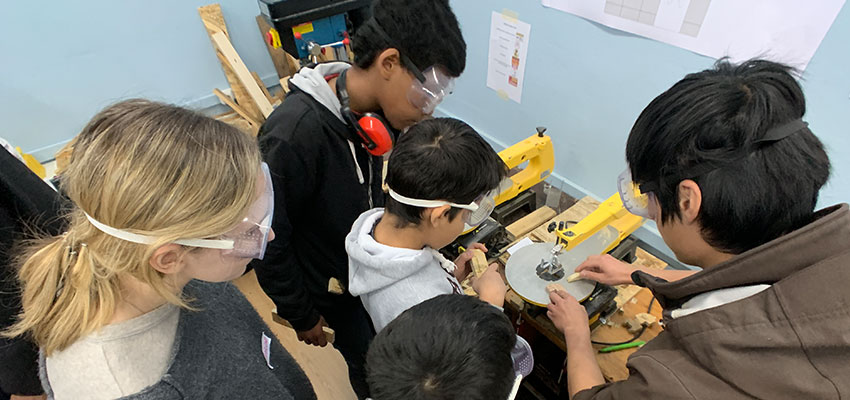 Franklin and Caroline at the Faros Horizon Center teaching refugee youth how to use the table saw during the Woodworking Olympics on the first day of the workshop.