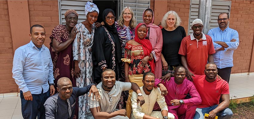 A group of standing smiling people.