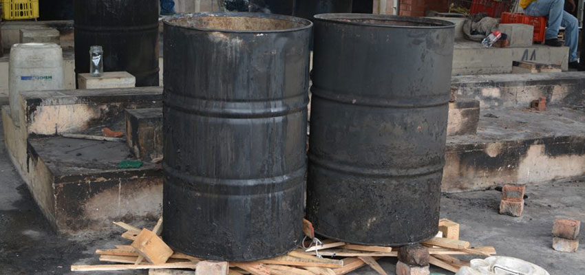 Conventional cooking setup: mild steel drums, on bricks and recycled pallet wood (fuel).