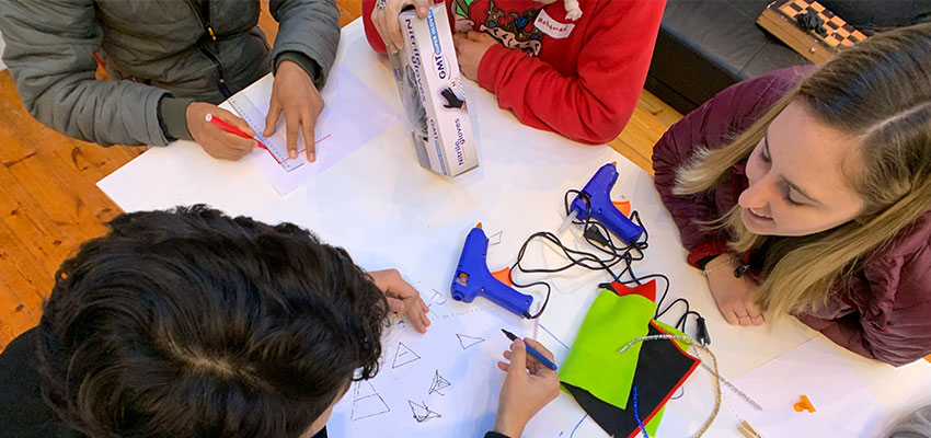 Caroline working with a group of students sketch modeling their power bank case/phone stand ideas.