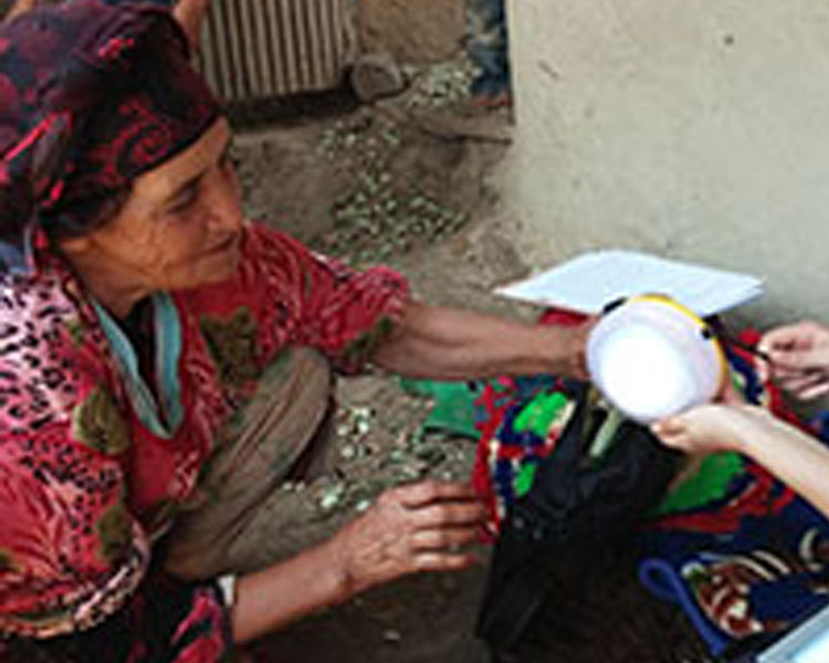 A woman interacts with the SunKing Pro2 solar lantern during a field interview