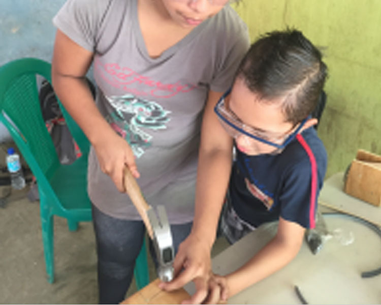 Learning to use a hammer.