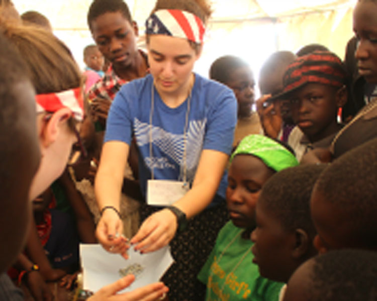 Rachel helps students measure the strength of their spaghetti marshmallow tower. (Photo: Nai Kalema)