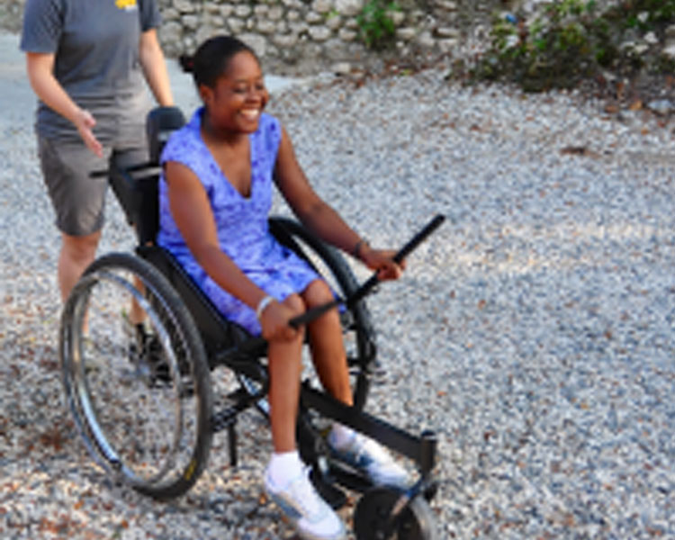 Tish Scolnik, CEO of GRIT (and 2012 D-Lab Scale-Ups fellow) accompanies a woman testing out the GRIT Leveraged Freedom Chair in Haiti. 