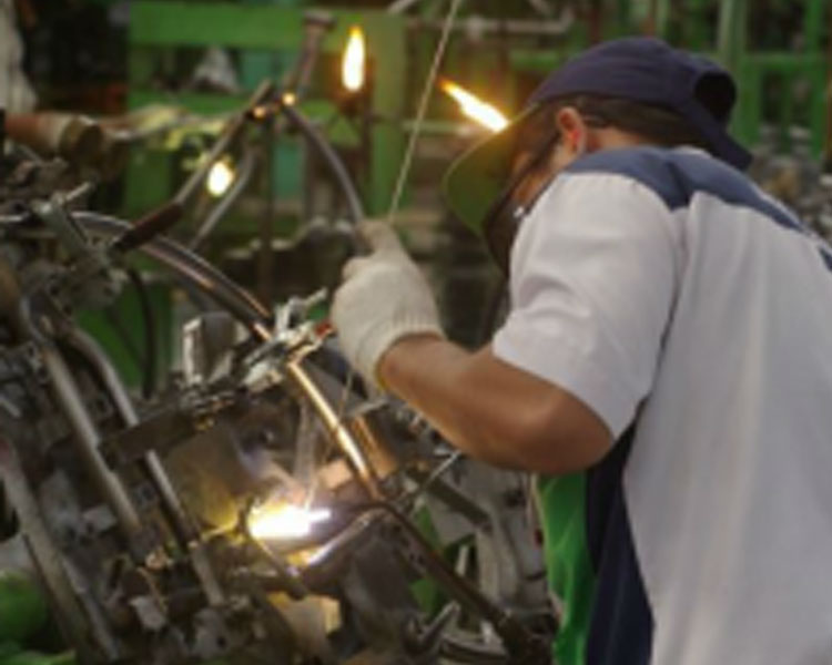 A worker in Jakarta, Indonesia mass-produces low-cost rugged offroad wheelchairs for bulk purchase by an international humanitarian organization