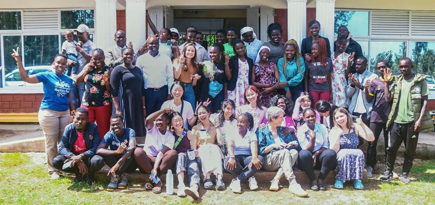 Large group of smiling people outside posing for a photograph.