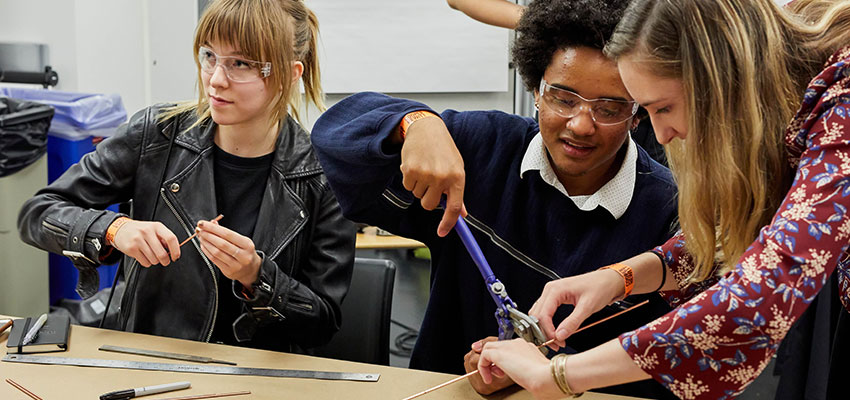 D-Lab alumna Caroline Morris assists students during the D-Lab hot-wire foam cutter "Skill Drill."