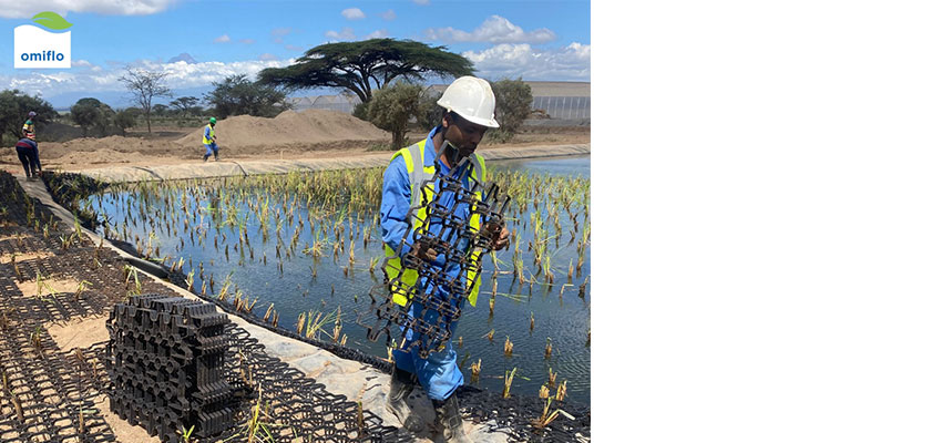 Man in protective gear standing in water with netted grid.