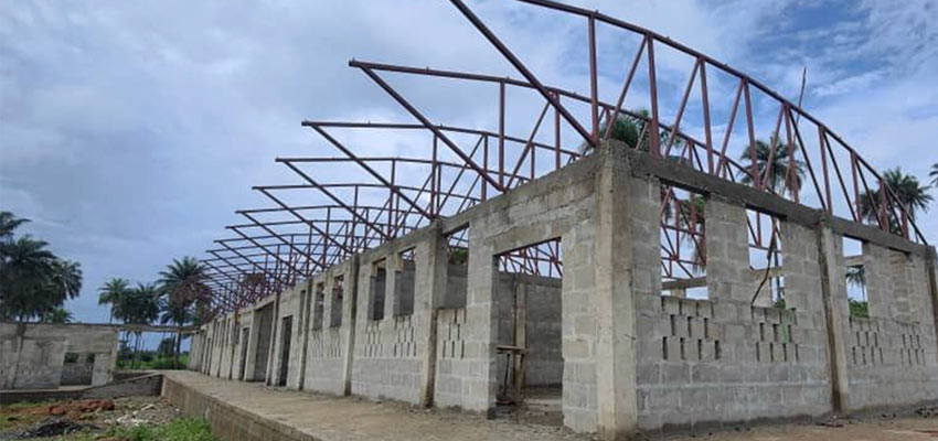 The roof trusses are tubular steel, welded in a jig. The roof is elevated to promote airflow under it, to remove some of the heat from absorbed solar radiation.