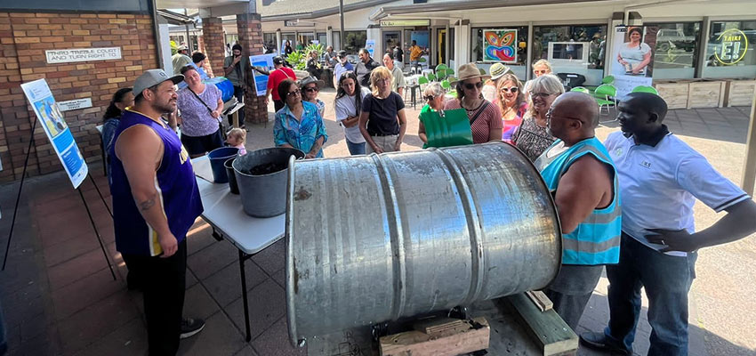 A group of people around a large horizontal barrel.